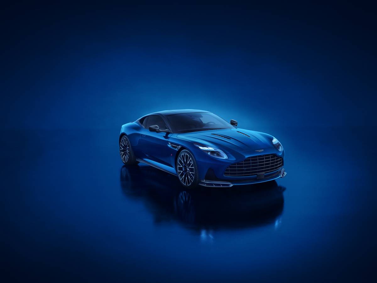Aston Martin DB11 in livrea blu scuro con luci a LED su sfondo scuro, design elegante e linee sportive.