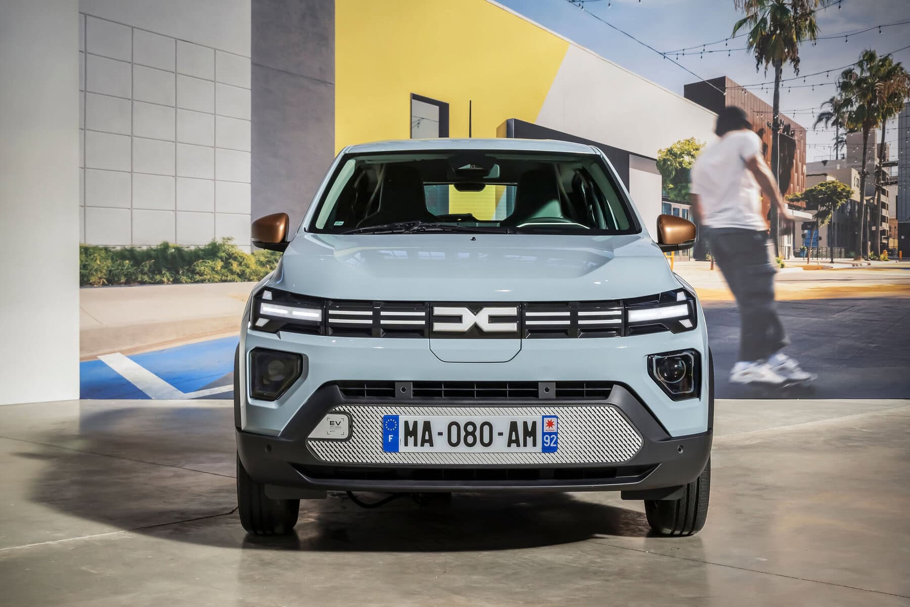 Auto elettrica Dacia Spring 2026, vista frontale, SUV compatto, design innovativo, ambiente urbano, carica zero emissioni, tecnologia verde, veicolo sostenibile, auto eco-friendly, modello futuristico.