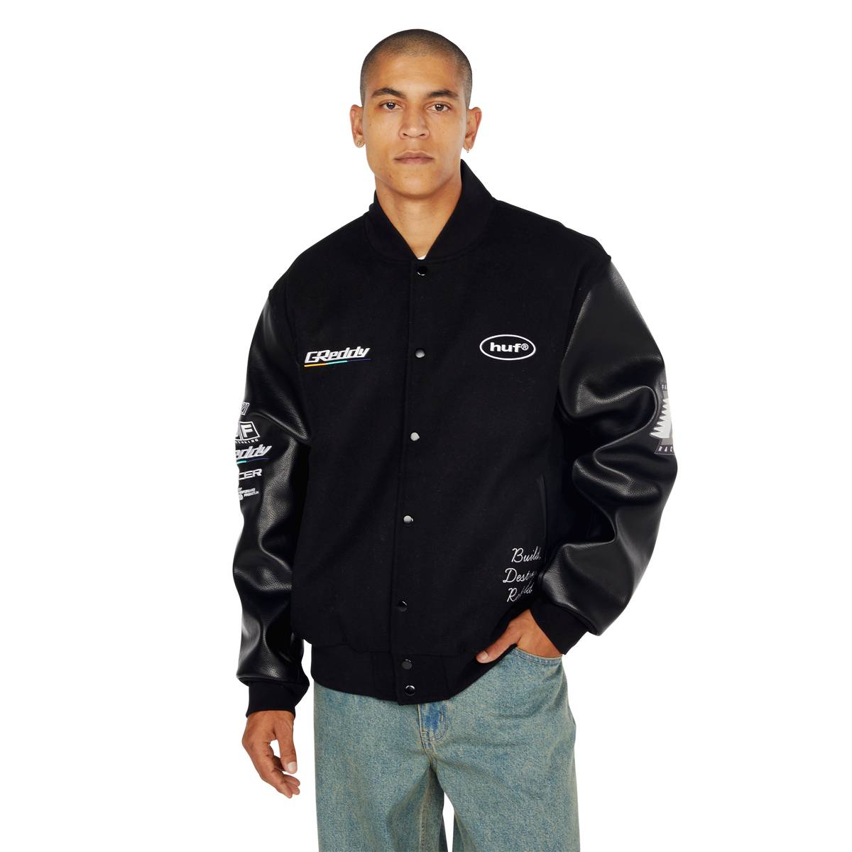 Giubbino varsity nero con patch logo HUF e dettagli in pelle stile streetwear. Abbigliamento moda uomo casual. Perfetto per look sportivi con stile.