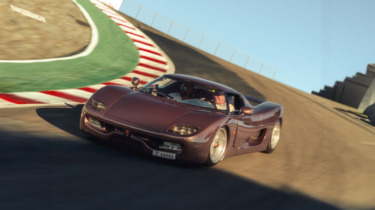 Auto sportiva d'epoca in corsa sulla pista con curva a destra, velocità elevata e dettaglio del design automobilistico classico.