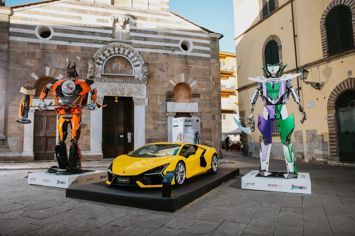 Robot automobilismo e supercar Lamborghini in esposizione in centro storico, scultoree statue robotiche di auto e robot fantastici, evento innovativo e tecnologico, automobili sportive di lusso, tecnologia avanzata.