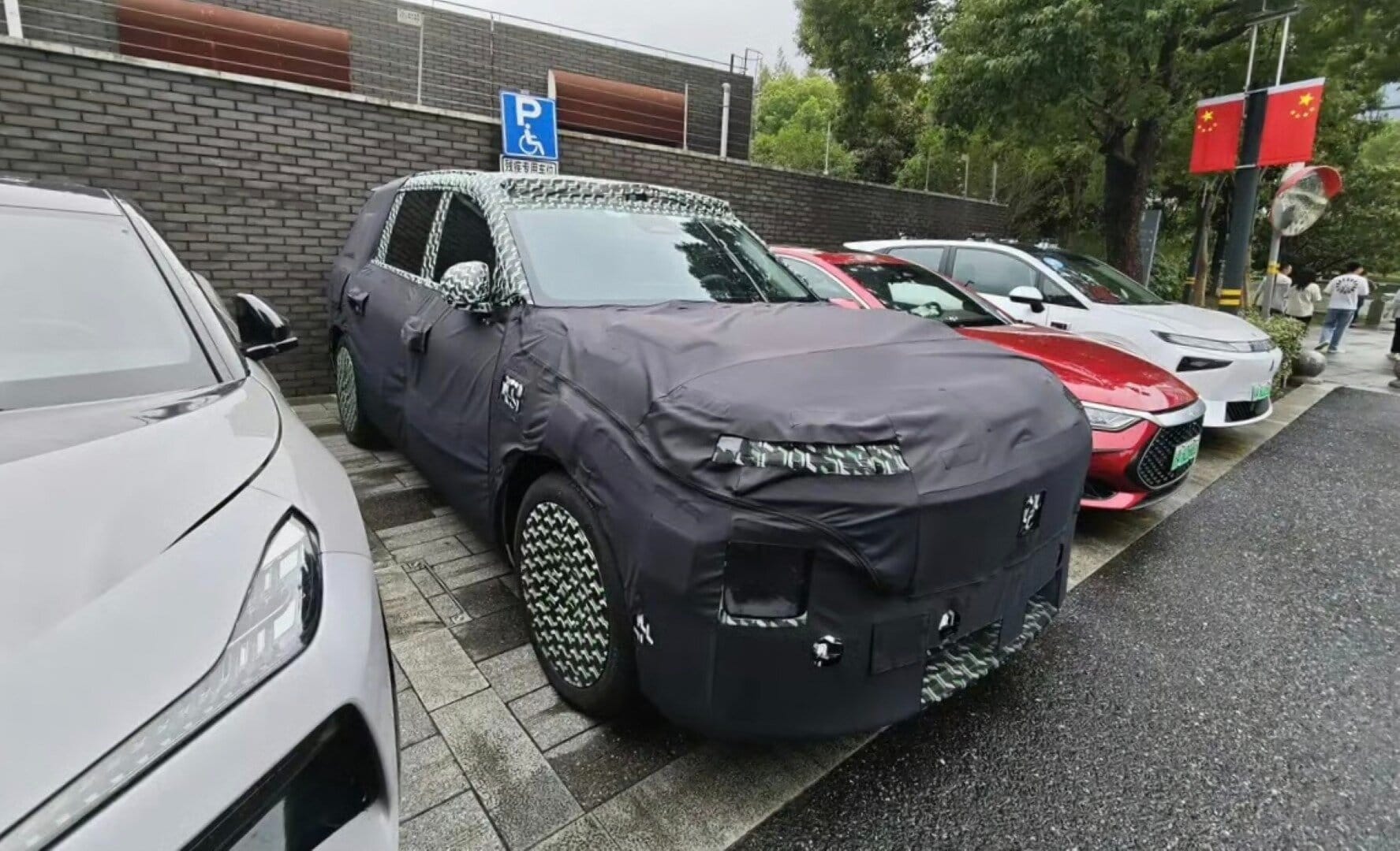 Auto Xiaomi in fase di test con copertura camouflage, probable lancio di un nuovo modello 2026; auto sportiva e innovativa in prova su strada.