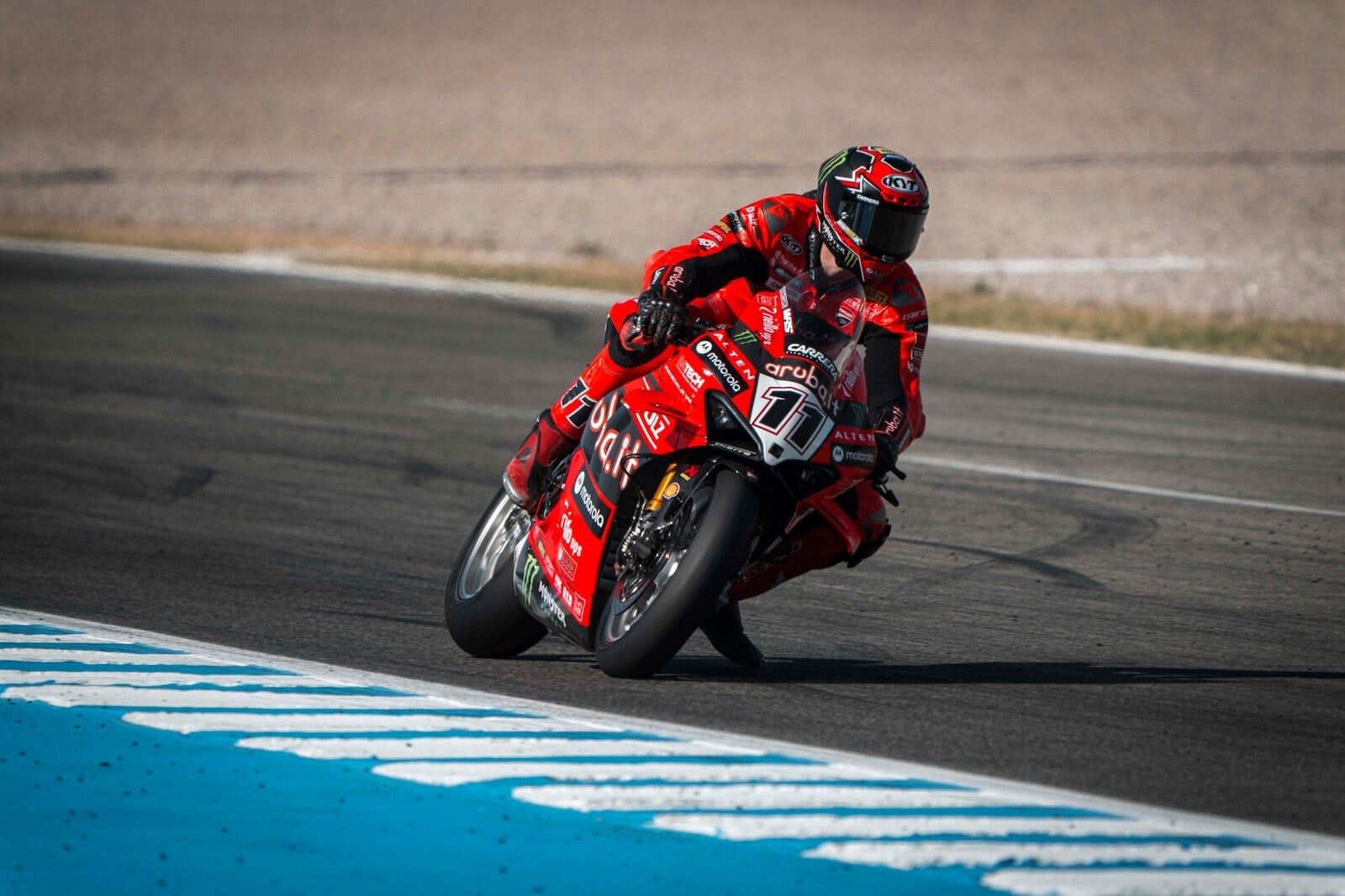 Cavaliere in gara su moto da corsa rossa durante un evento di motociclismo.