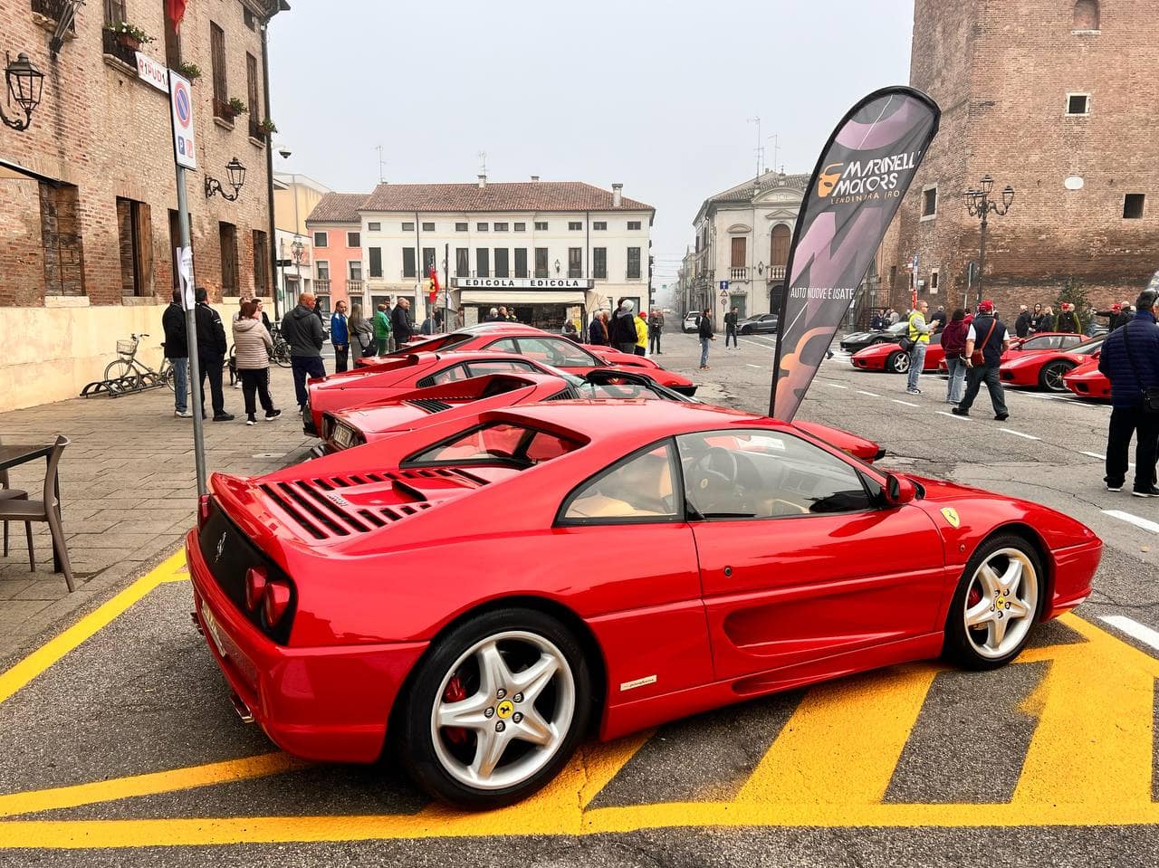 Ferrari Testarossa rossa in mostra ad evento automobilistico in centro città.