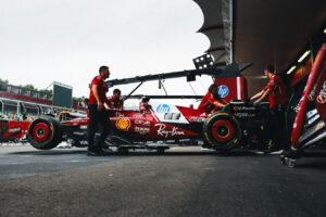 Ferrari Formula 1 2025 in stazione di pit stop con team che lavora nel box.