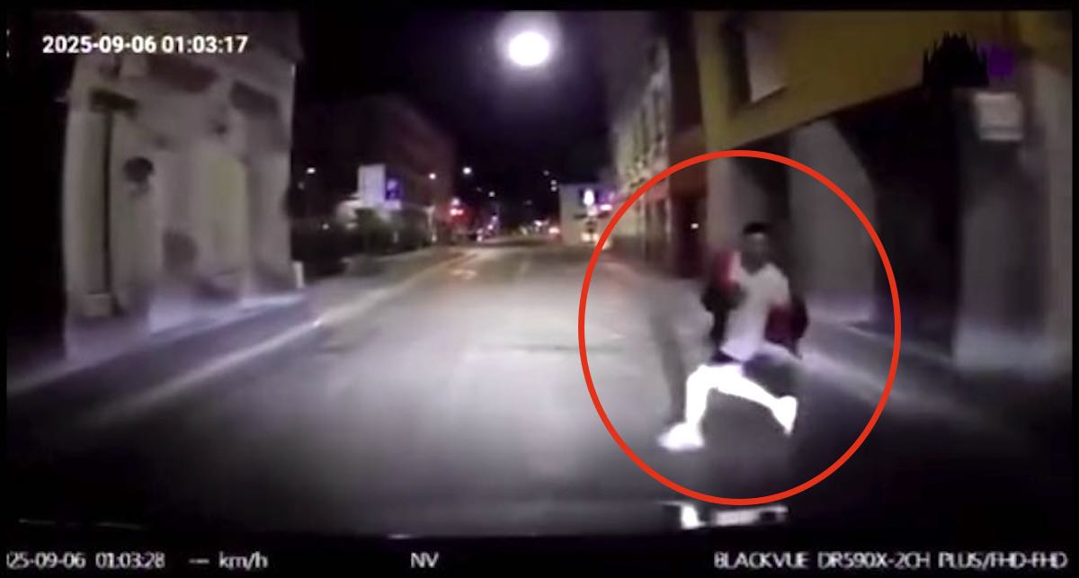 Persona che attraversa la strada di notte con il cruscotto di un'auto, situazioni di strada e sicurezza stradale, immagini di incidente stradale in città, video sorveglianza di notte.