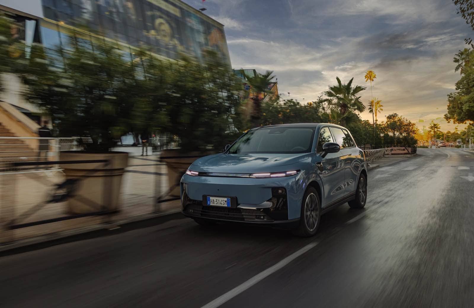 Auto elettrica Leapmotor B10, veicolo eco-friendly in movimento su strada urbana durante il tramonto, ideale per notizie sulle auto sostenibili e tecnologie innovative.