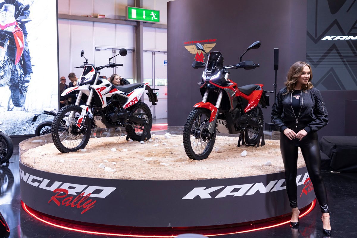 Moto enduro elettrica Kawasaki, moto da rally elettrica con design innovativo e sostenibile, esposta alla fiera motociclistica, promozione veicoli a zero emissioni, tecnologia all’avanguardia.