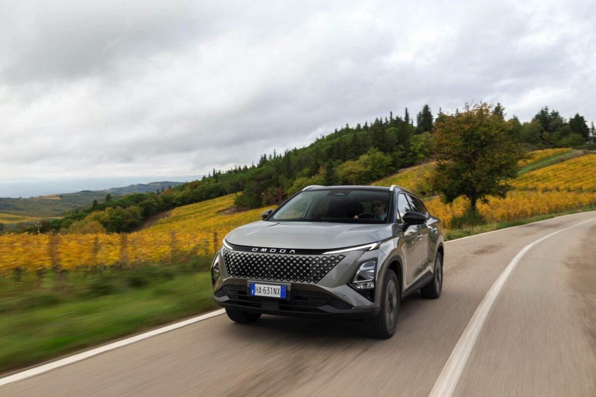 Omoda 5 SHS-S in viaggio tra colline e vigneti durante una giornata nuvolosa.