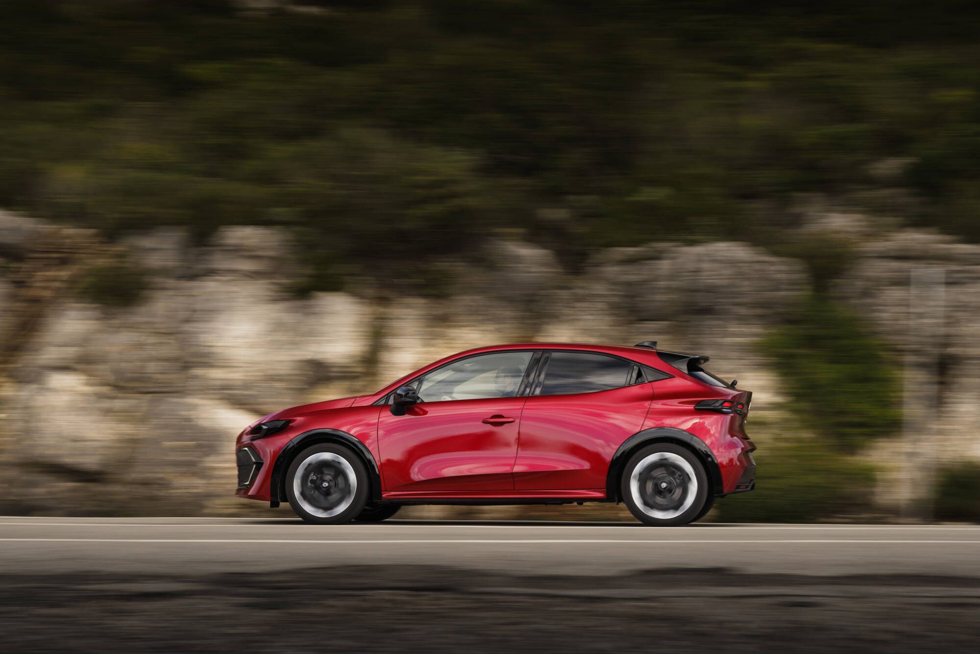 Auto sportiva Nuova Renault Clio 2026 rossa in corsa, con design aerodinamico e dettagli eleganti, ideale per appassionati di auto e motori.