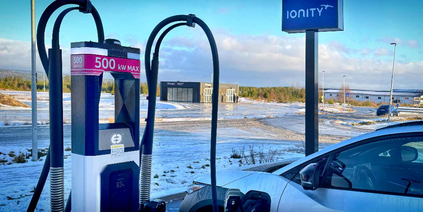 ALT: Punto di ricarica ultra veloce Ionity in un'area all'aperto con paesaggio innevato e un'auto elettrica collegata, pronto per una ricarica rapida e efficiente.