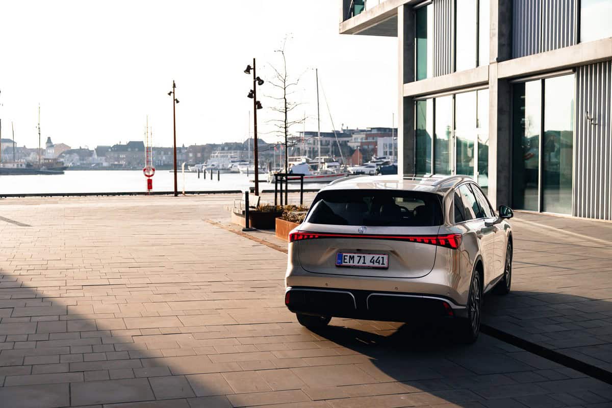 Auto elettrica parcheggiata in zona portuale con vista sul mare e i porticcioli, design moderno, sostenibilità e mobilità elettrica.