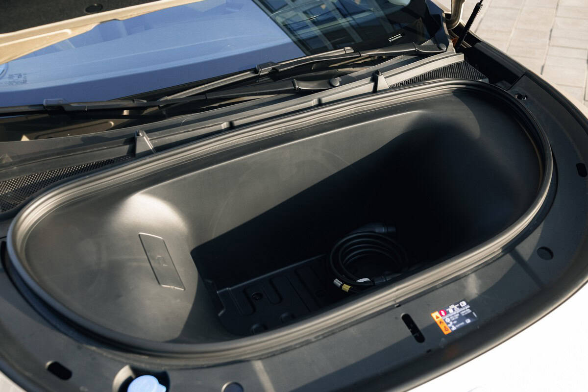 Altra vista del vano batteria dell'auto elettrica, con cavo di alimentazione collegato pronto all’uso.