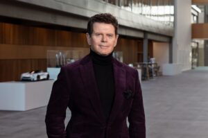 Immagine del Prof Gerry McGovern un uomo in abito elegante in un contesto moderno e sofisticato, ideale per articoli sulle ultime novità nel settore automobilistico di lusso, motori e eventi auto.