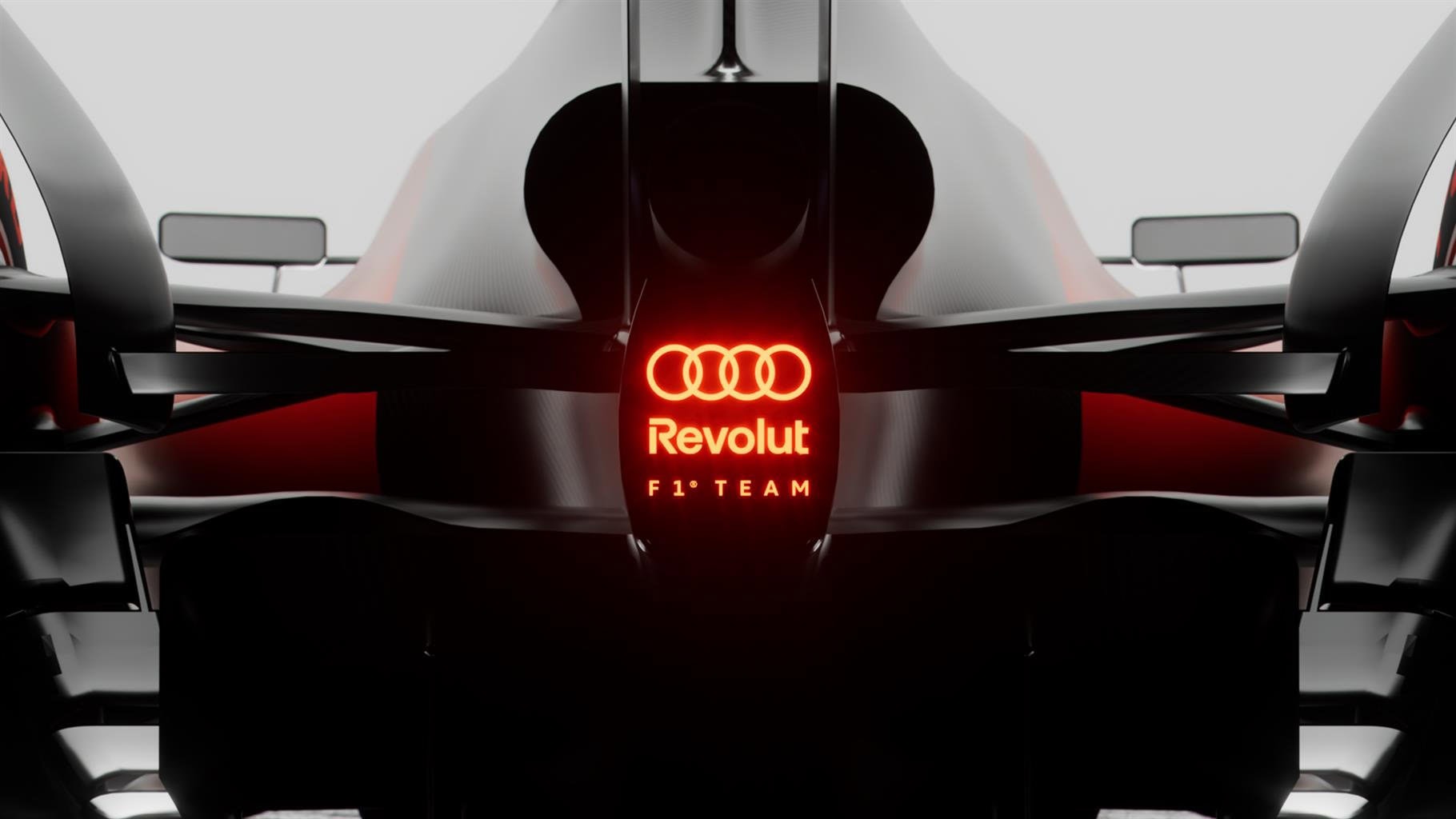 Dettaglio di un'auto da corsa Formula 1 Audi Revolution con logo illuminato rosso, stile futuristico, tecnologia avanzata, progettata per alte performance in circuito.