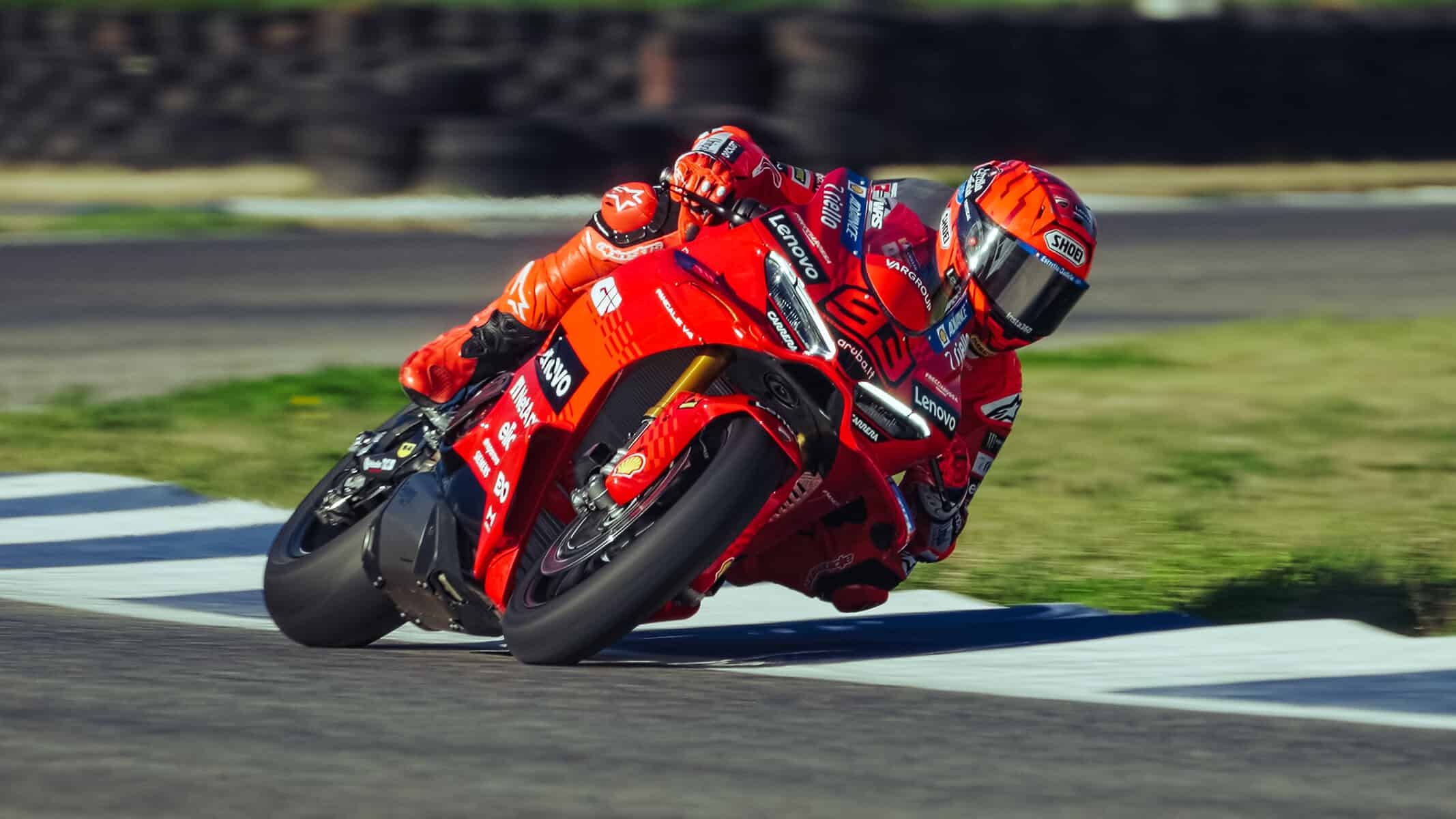 Marc Marquez in tuta rossa in piega su una Ducati Panigale V4 SBK 2026 durante un’azione in pista, con moto inclinata all’interno di una curva.