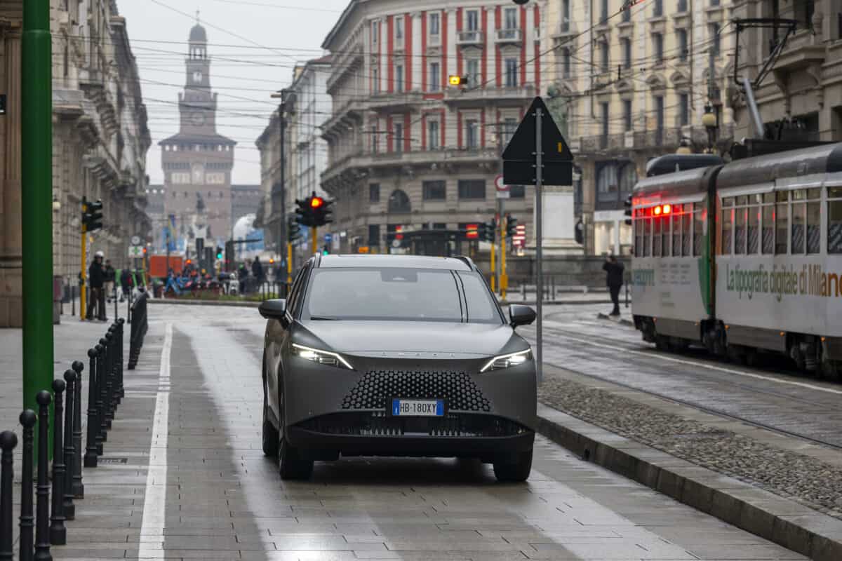Omoda 7 SHS-P nel centro di Milano, di fronte al Castello Sforzesco, con tram e traffico cittadino.
