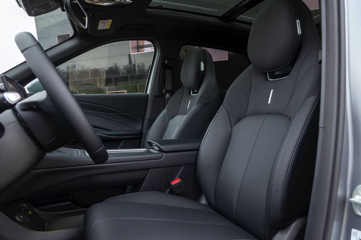 Interni Omoda 7 SHS-P grigi, vista laterale, sedili anteriori in pelle, abitacolo spazioso.