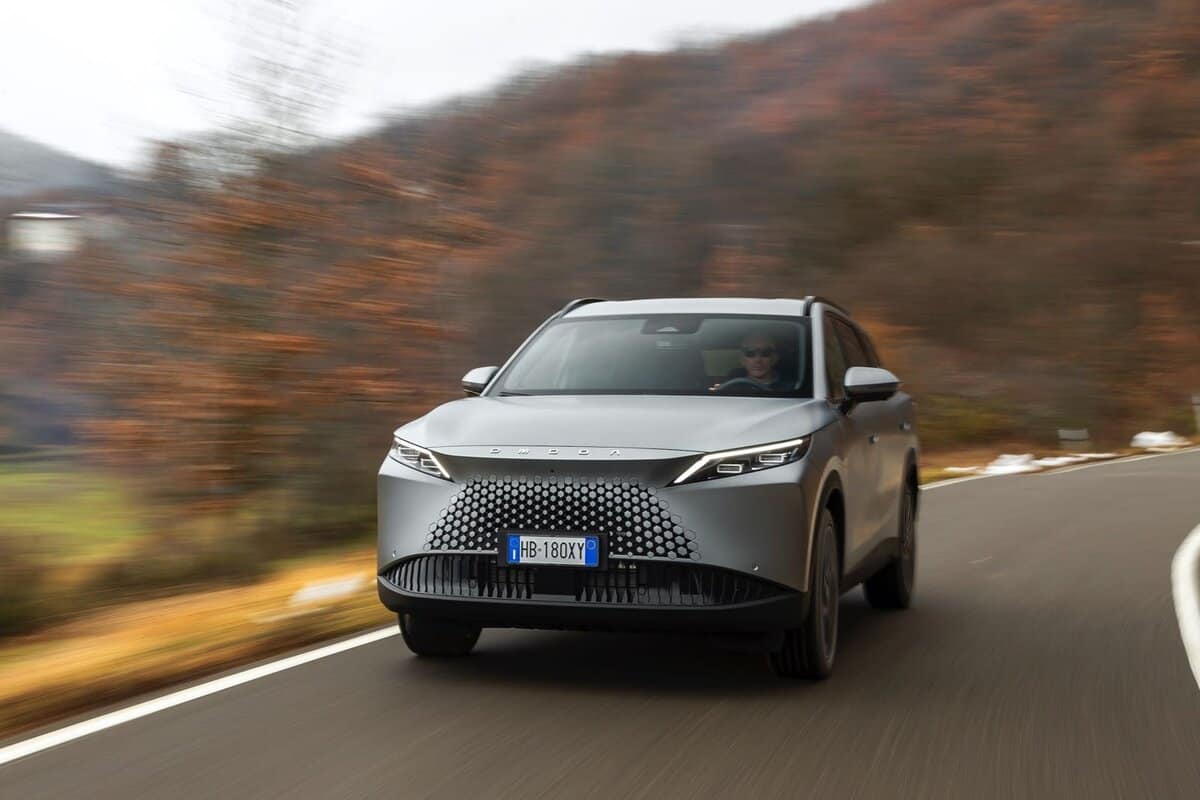 Omoda 7 SHS-P grigio in curva su strada di campagna, vista frontale.