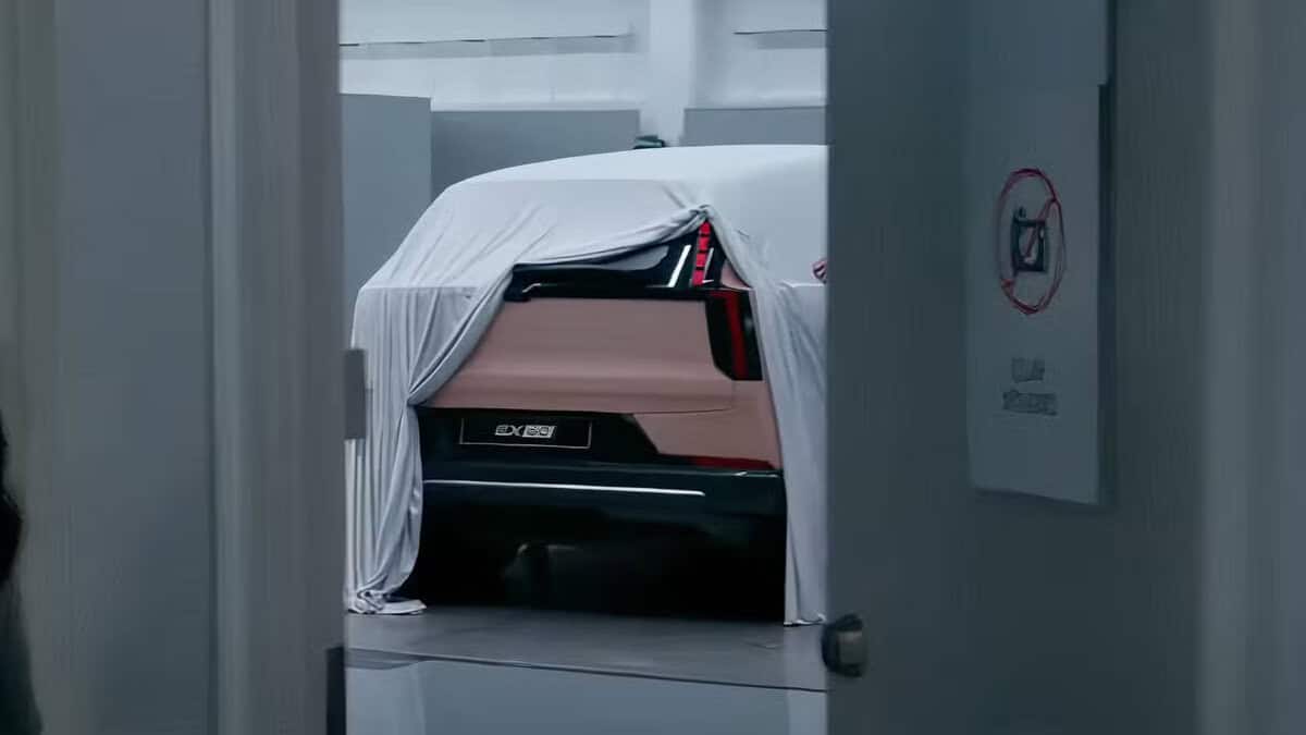 Auto Volvo coperta in design studio, angolazione posteriore, parzialmente visibile sotto un telo bianco.