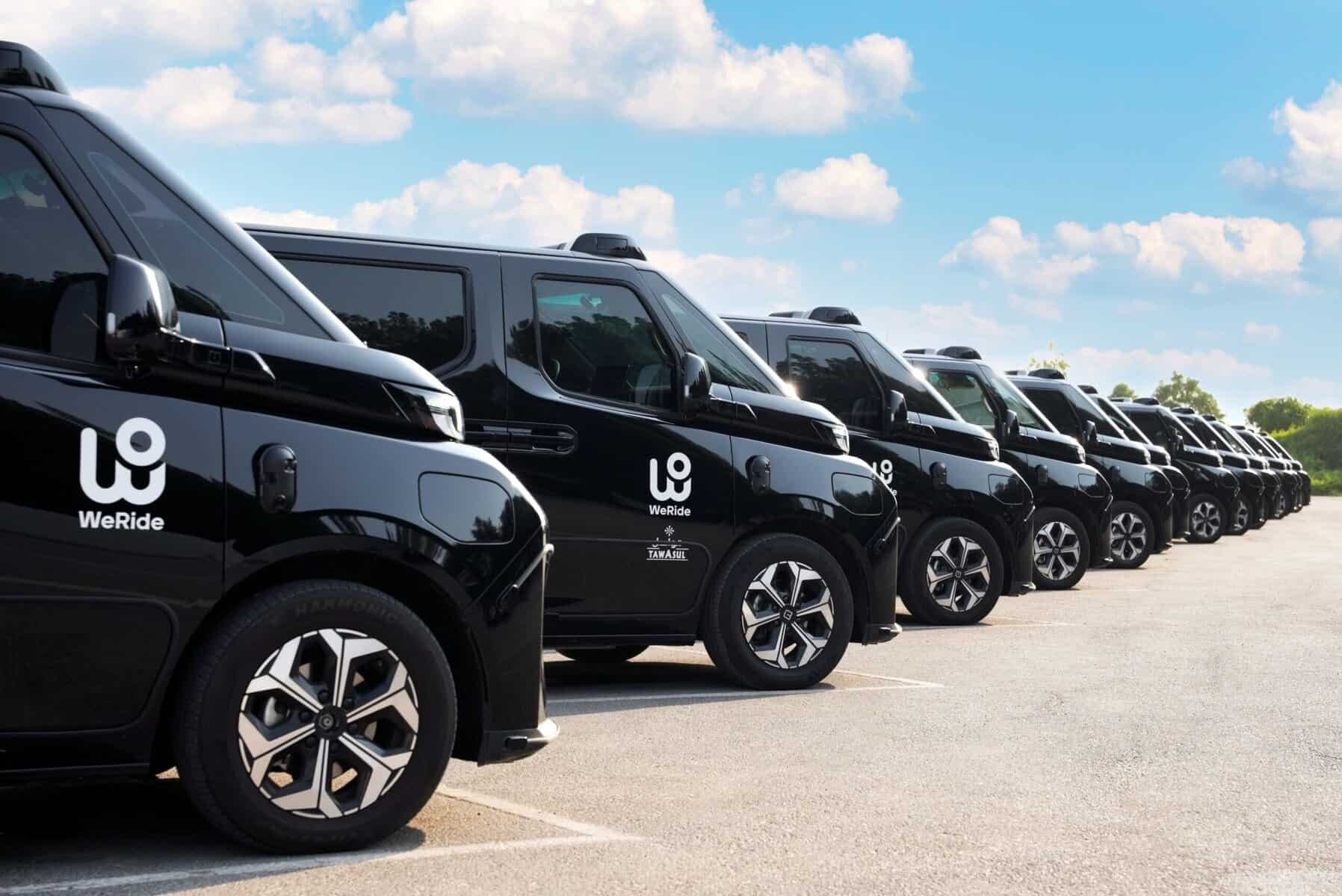 Veicoli elettrici robotaxi WeRide parcheggiati, veicoli condivisi per mobilità sostenibile per servizi di mobilità urbana.
