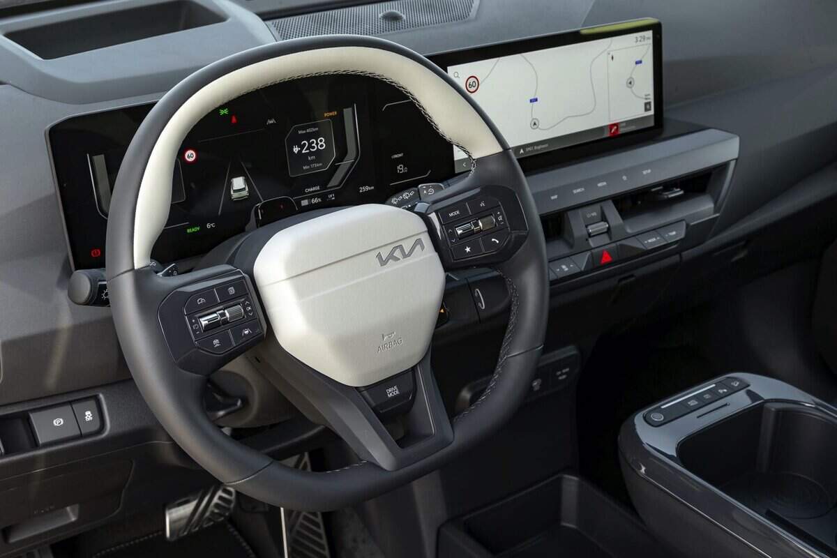 Volante Kia EV5, display digitale e comandi, auto elettrica ferma.