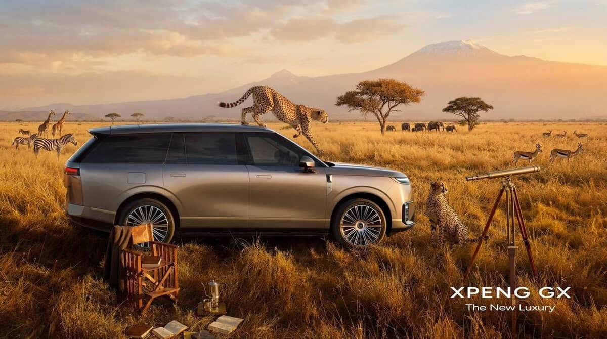 XPENG GX SUV argento in safari con animali e montagna sullo sfondo. Cheetah sul cofano. Scatto di profilo.
