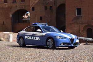 Alfa Romeo Giulia della Polizia di Stato parcheggiata su piazza lastricata.