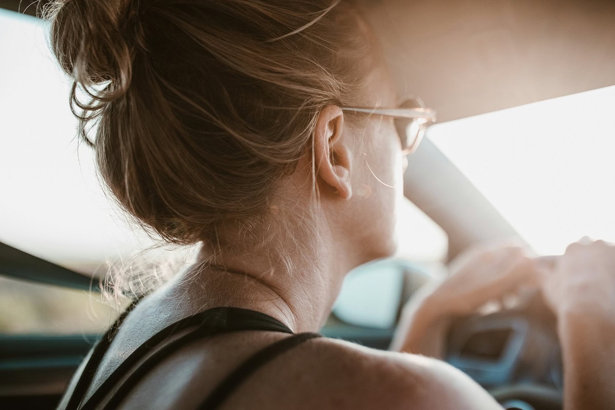 Donna tiene il volante in maniera sicura per guidare in autostrada