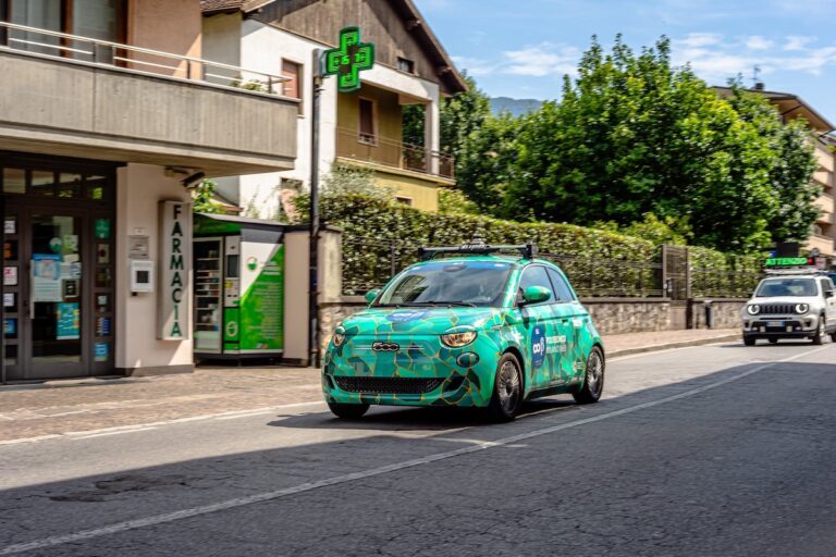 Fiat 500e elettrica del Politecnico di Milano in marcia davanti a una farmacia