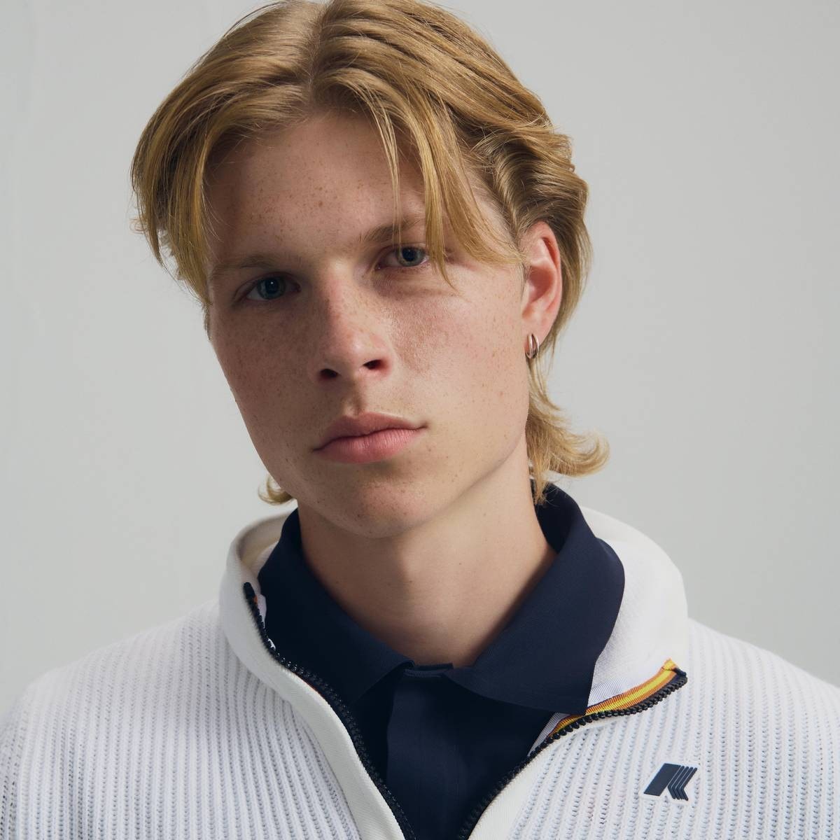 Primo piano di giovane golfista con maglione bianco K-Way