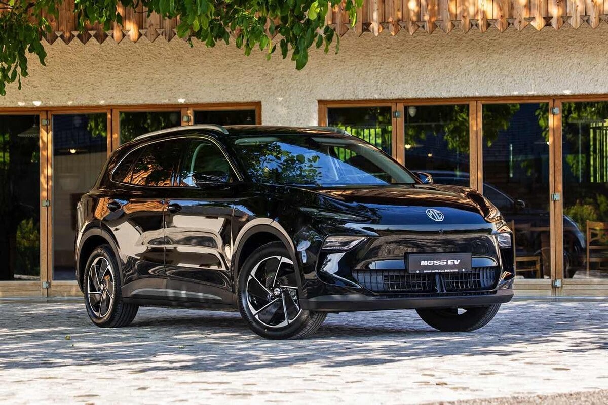 MG S5 EV 2025 nera, vista frontale tre quarti su sfondo rustico