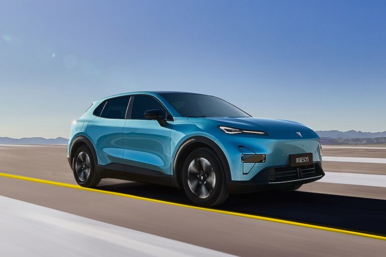 SUV elettrico Deepal S05 azzurro in movimento su strada asfaltata in un paesaggio desertico, sotto cielo limpido.