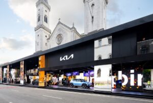 Padiglione Kia con design moderno e auto elettriche esposte, allestito davanti a una chiesa storica durante lo IAA Mobility di Monaco.