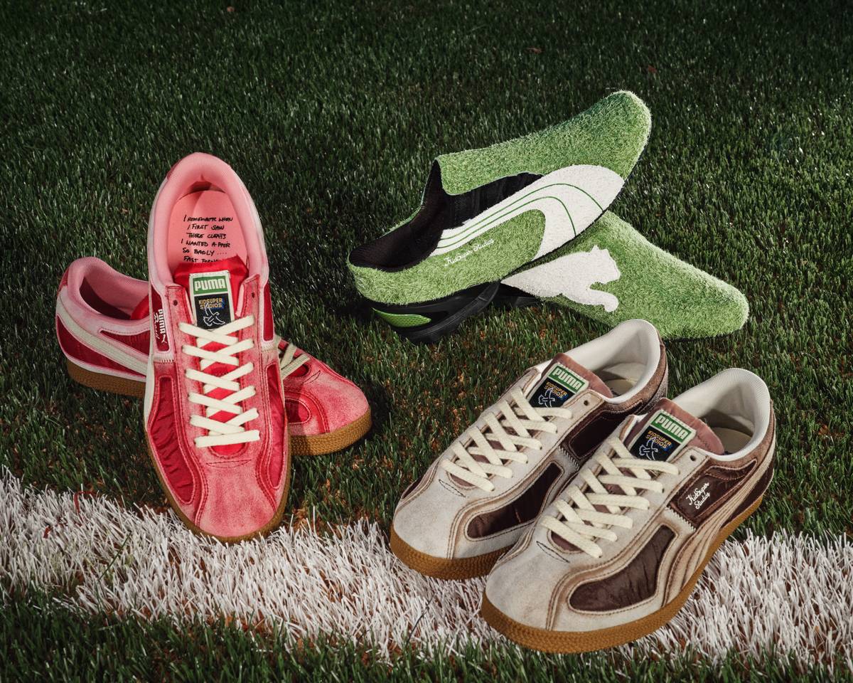 Scarpe sportive Puma con design vintage e colorata su campo di calcio, con scarpette da ginnastica e calzini green con logo Puma. Atmosfera dinamica e sportiva, perfetta per appassionati di calcio e moda sportiva.