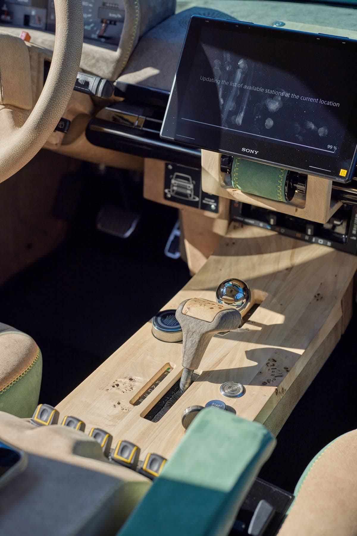 Sezione del cruscotto di un'auto moderna con dettagli in legno e tecnologia avanzata, tra cui schermo digitale e comandi al volante, perfetta per gli appassionati di motori e innovazione automobilistica.