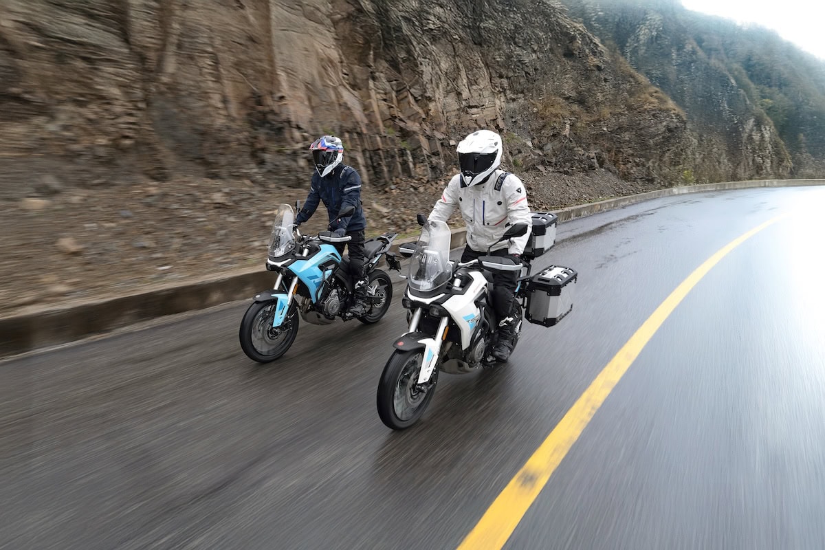 Due moto Morbidelli T502X affrontano una curva su asfalto bagnato, con il motociclista in bianco leggermente in vantaggio su quello in nero.