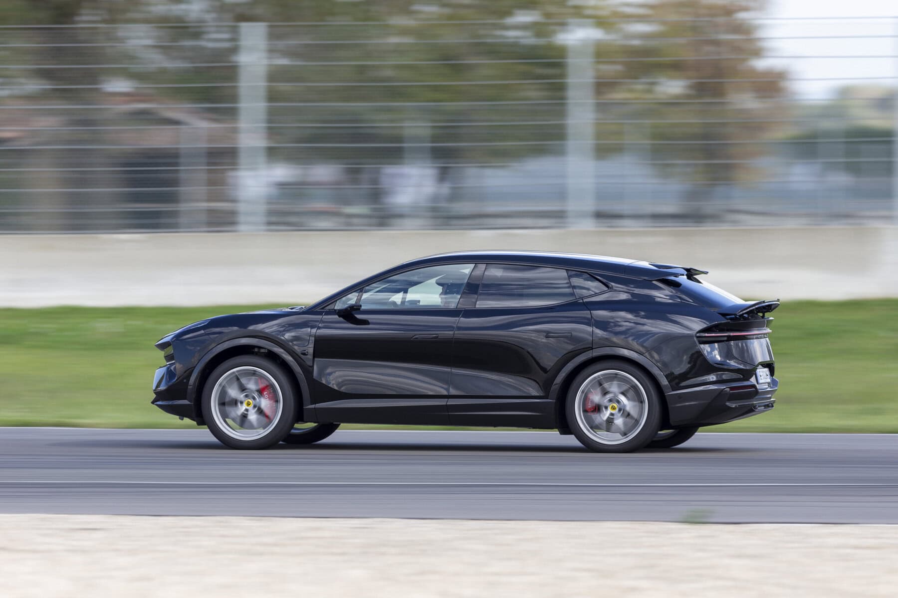 Auto sportiva elettrica Lotus Eletre 900 Sport Carbon in movimento su pista, tecnologia avanzata e design aerodinamico, vettura di fascia alta, performance e automotive di lusso, driving innovation.