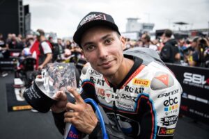 Pilota di moto da corsa che tiene il trofeo del Gran Premio di Mandalika 2023 in pista mondiale MotoGP.
