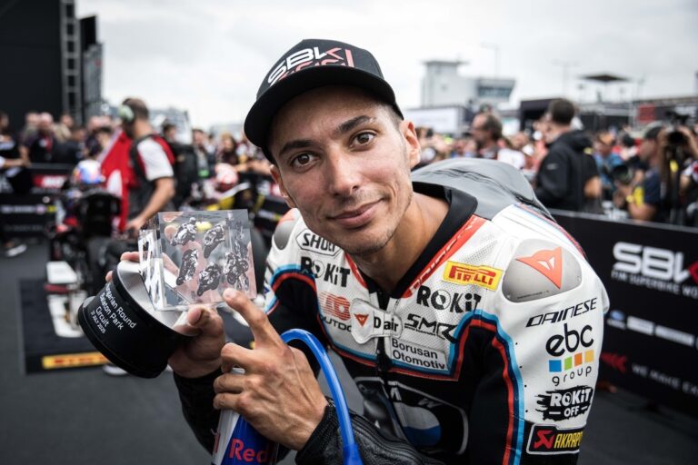 Pilota di moto da corsa che tiene il trofeo del Gran Premio di Mandalika 2023 in pista mondiale MotoGP.
