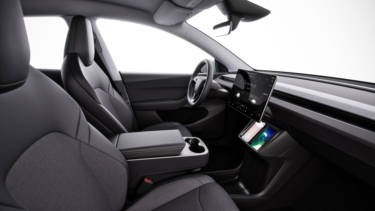 Interno di un'auto elettrica moderna con comandi digitali, schermi touch e sedili ergonomici, design minimalista e tecnologia avanzata.