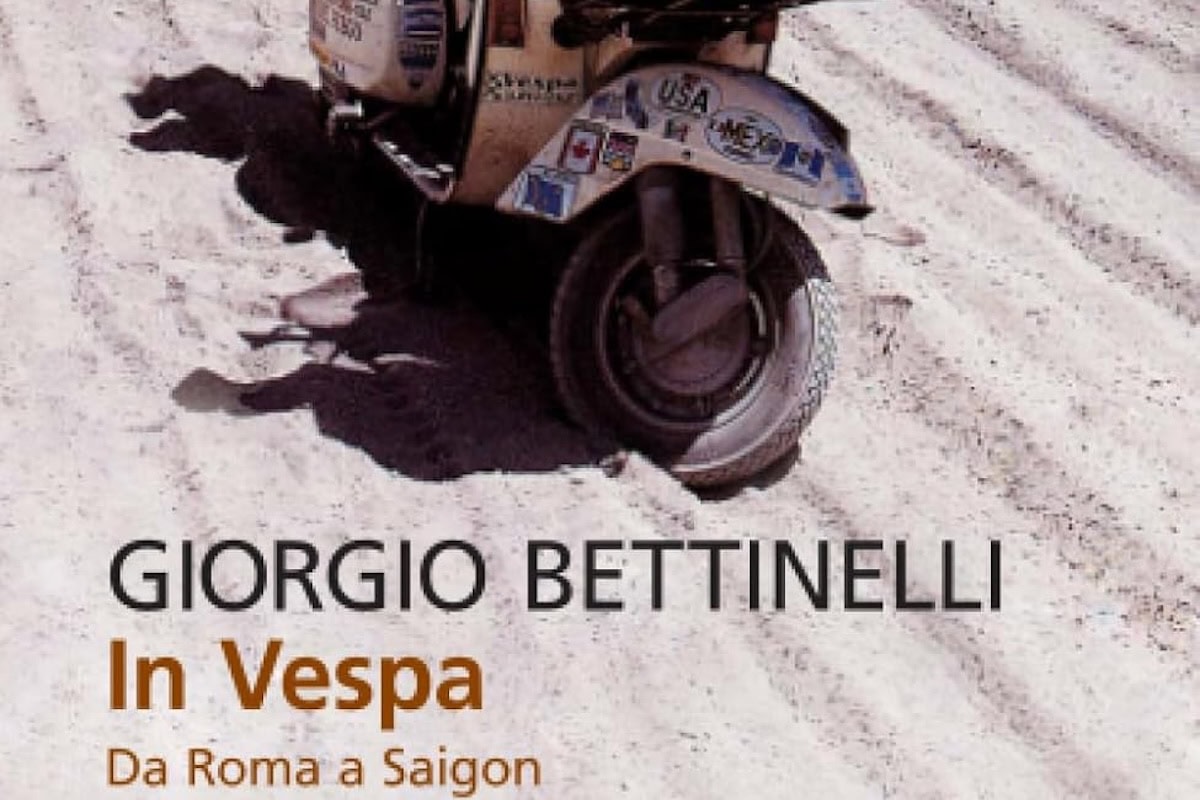 Scooter Vespa Piaggio con decalcomanie vintage sulla spiaggia sabbiosa, ombra proiettata sulla sabbia, destinazione in Vietnam, viaggio da Roma a Saigon.