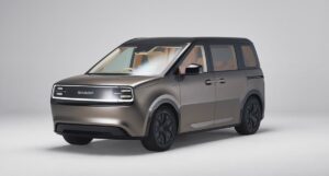 Auto compatta elettrica design futuristico in tinta grigia con dettagli nero opaco, carrozzeria moderna e innovativa, perfetta per la città e la mobilità sostenibile.