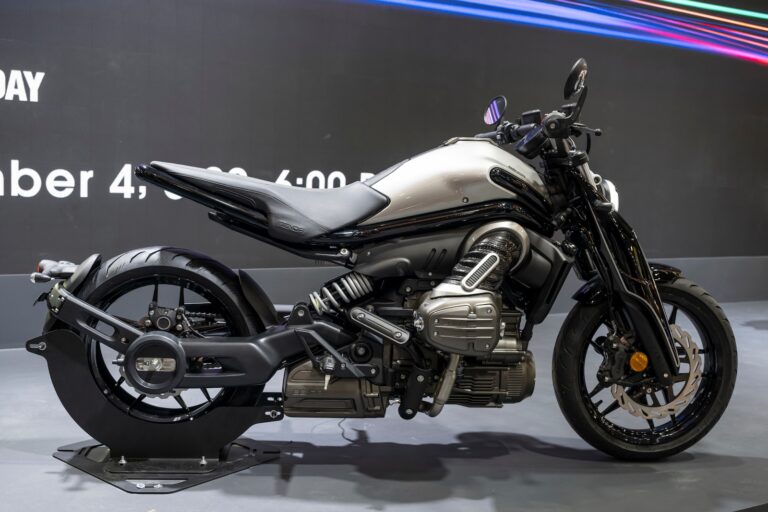 Motocicletta elettrica moderna con design audace e tecnologie innovative, esposizione in fiera con sfondo nero, ideale per appassionati di veicoli sostenibili e custom.
