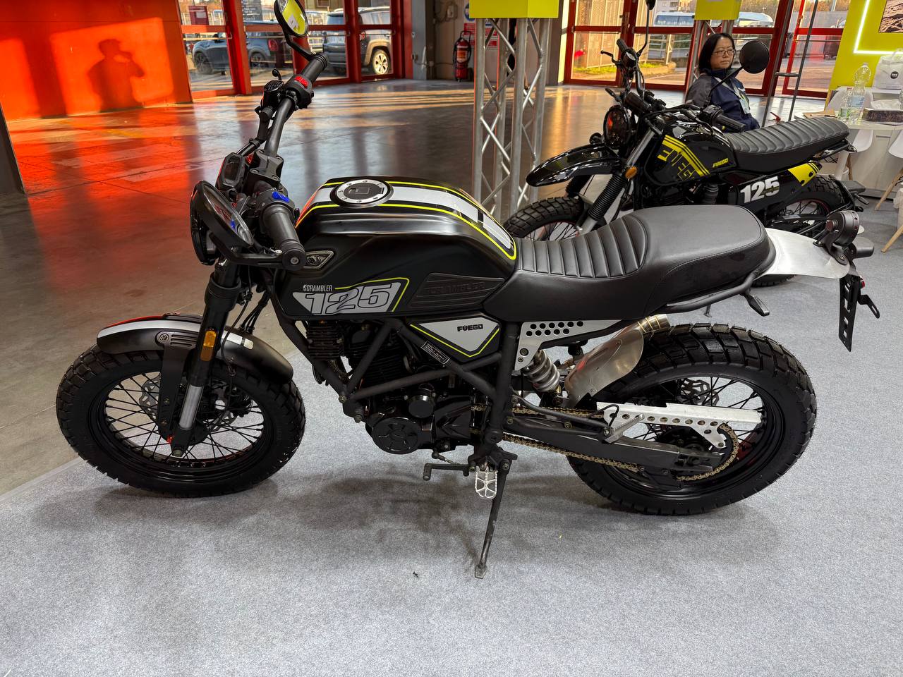 Moto da enduro Fuego Scrambler 125 con pneumatici tassellati, design retrò e motore potente, ideale per avventure off-road e stile urbano robusto.