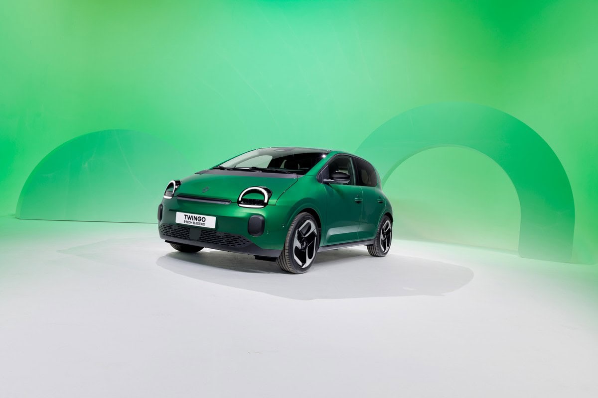 Auto elettrica compatta VW Twingo in verde brillante su sfondo verde.