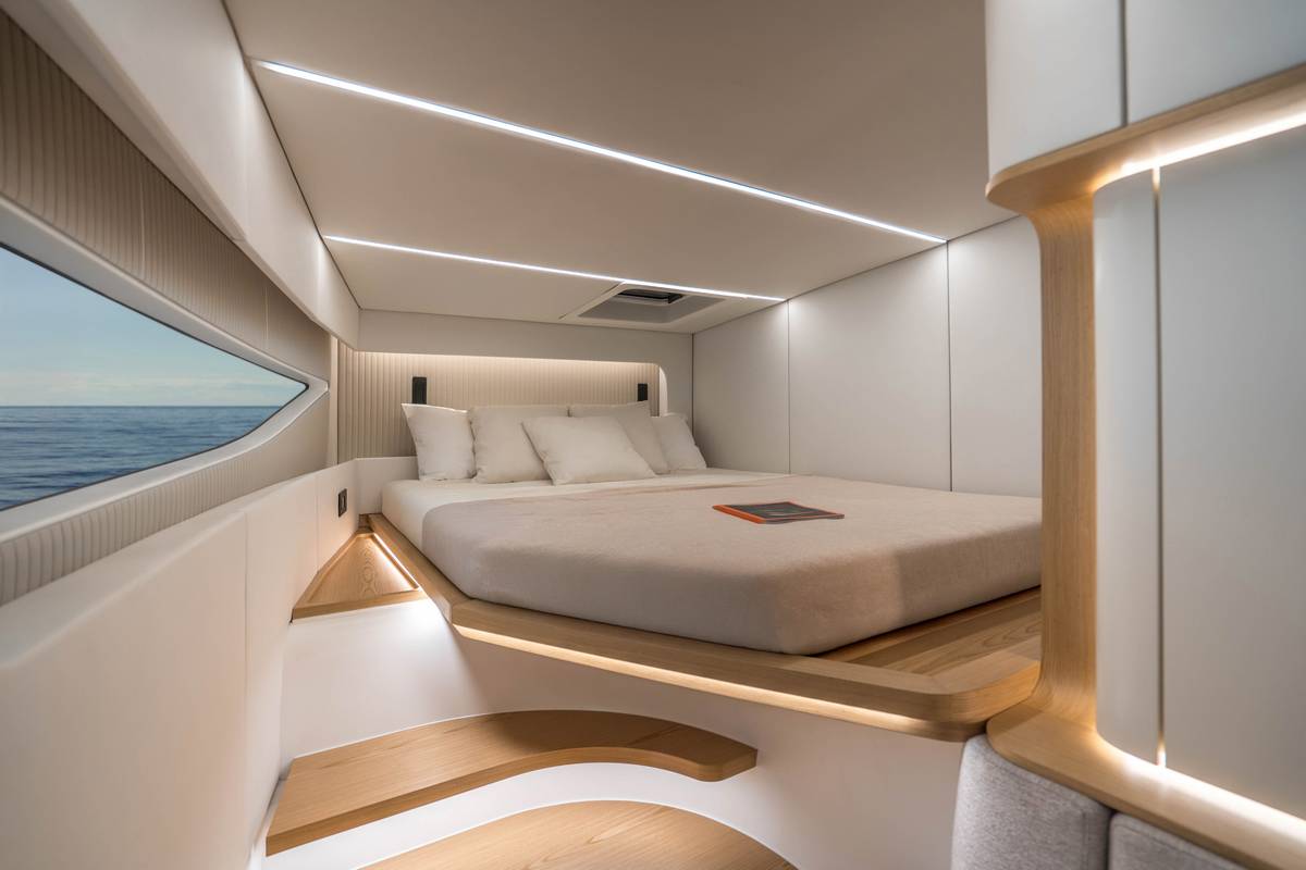 Interni di una cabina di Yacht di lusso con letto matrimoniale e vista mare. Design moderno, illuminazione LED e finiture in legno chiaro. Perfetto per crociere di alta classe.