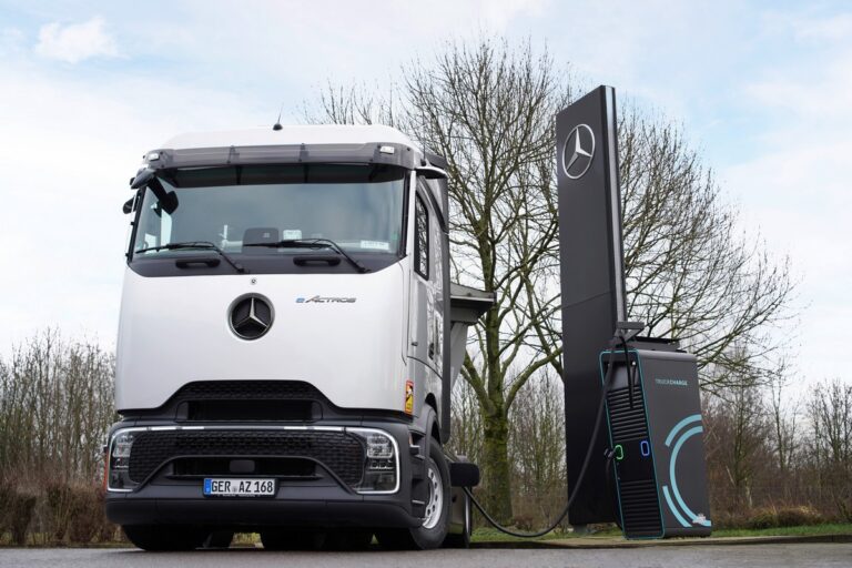 Veicolo elettrico Mercedes-Benz in ricarica presso stazione di ricarica pubblica, veicolo commerciale elettrico, sostenibilità e mobilità pulita, veicolo a zero emissioni, tecnologia innovativa.