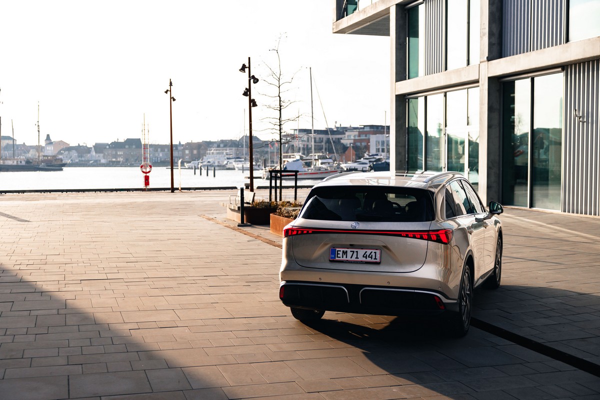 Auto elettrica parcheggiata in zona portuale con vista sul mare e i porticcioli, design moderno, sostenibilità e mobilità elettrica.