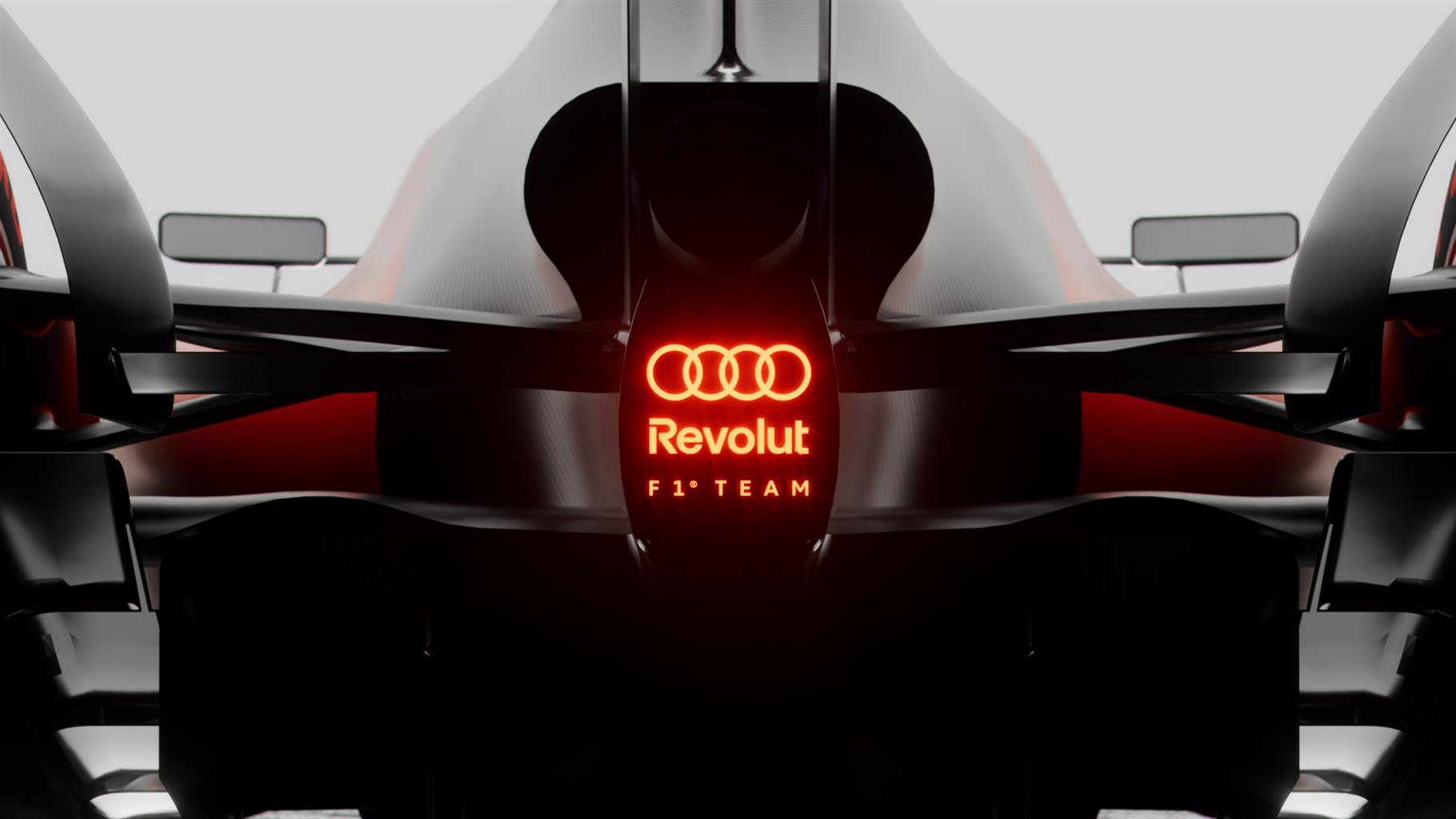 Dettaglio di un'auto da corsa Formula 1 Audi Revolution con logo illuminato rosso, stile futuristico, tecnologia avanzata, progettata per alte performance in circuito.